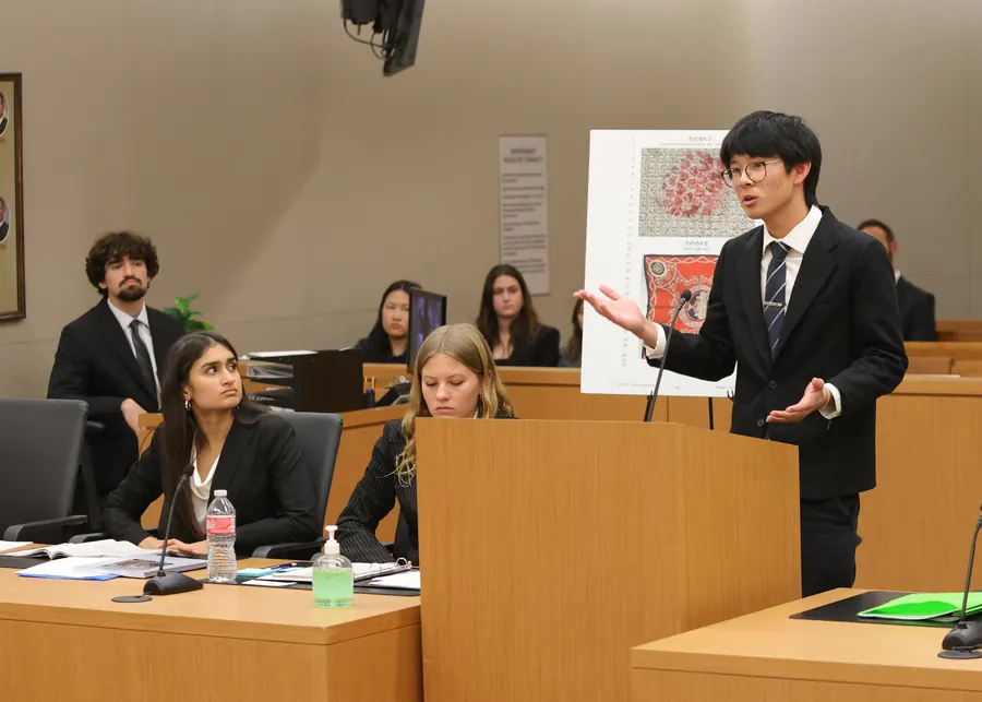 A student speaking at a lectern during a debate