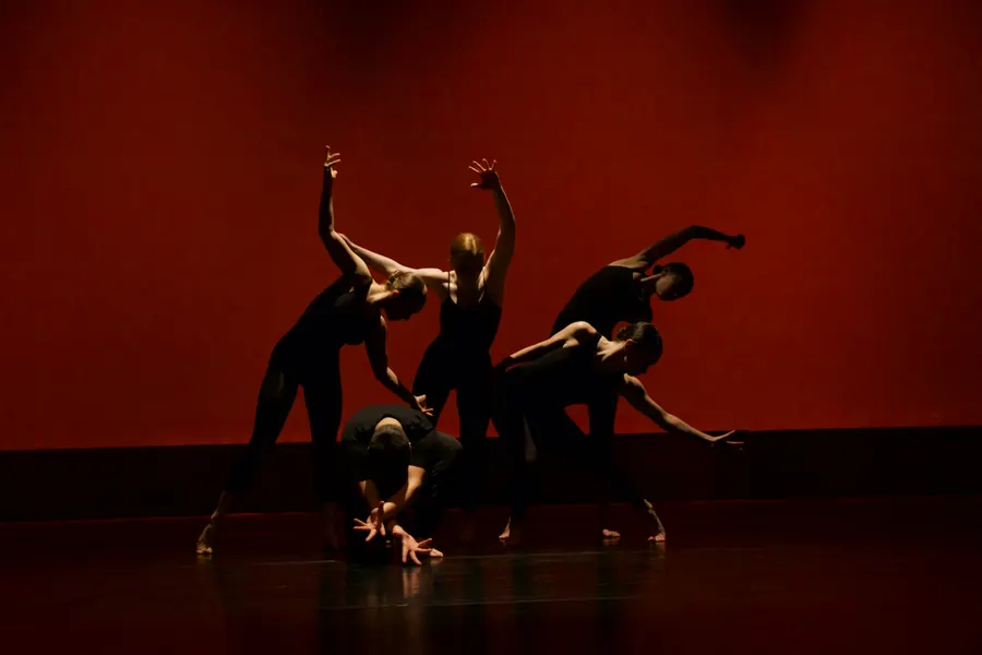 Dancers performing on a red-lit stage